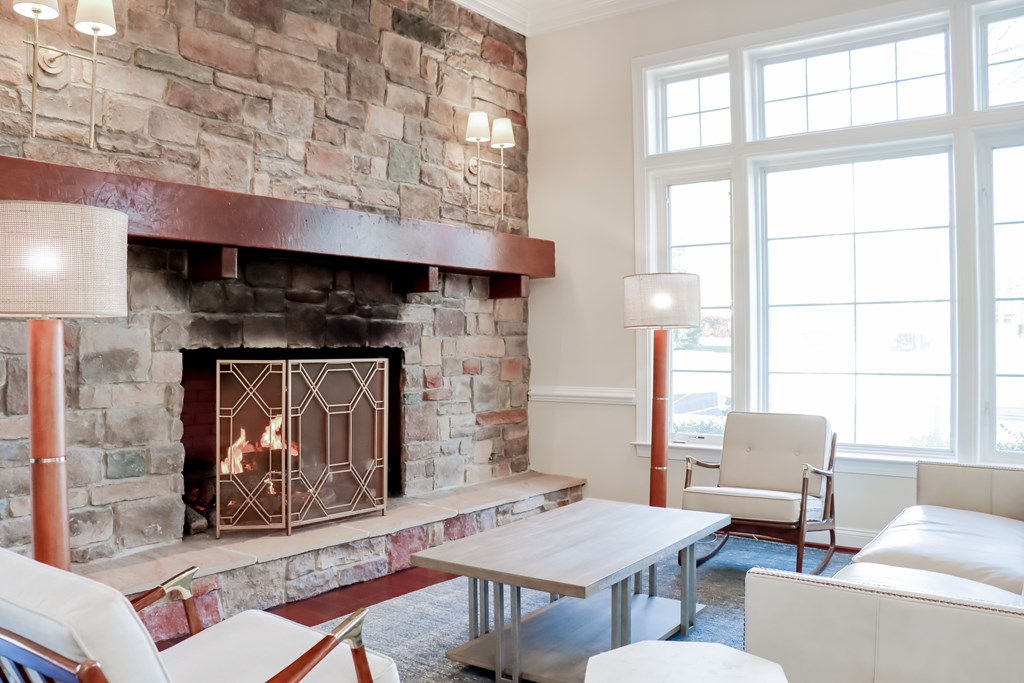 a living room with a fireplace and a table and chairs at Broadlands Apartments, VA 20148
